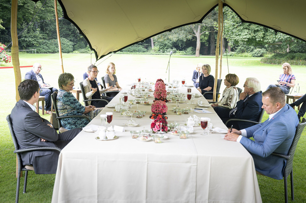 Bundespräsident Frank-Walter Steinmeier und Elke Büdenbender im Gespräch mit den Gästen der Kaffeetafel des Bundespräsidenten zum Thema "Beschränkungen in der Corona-Krise: Schattenseiten und Lichtblicke" im Präsidentengarten von Schloss Bellevue.